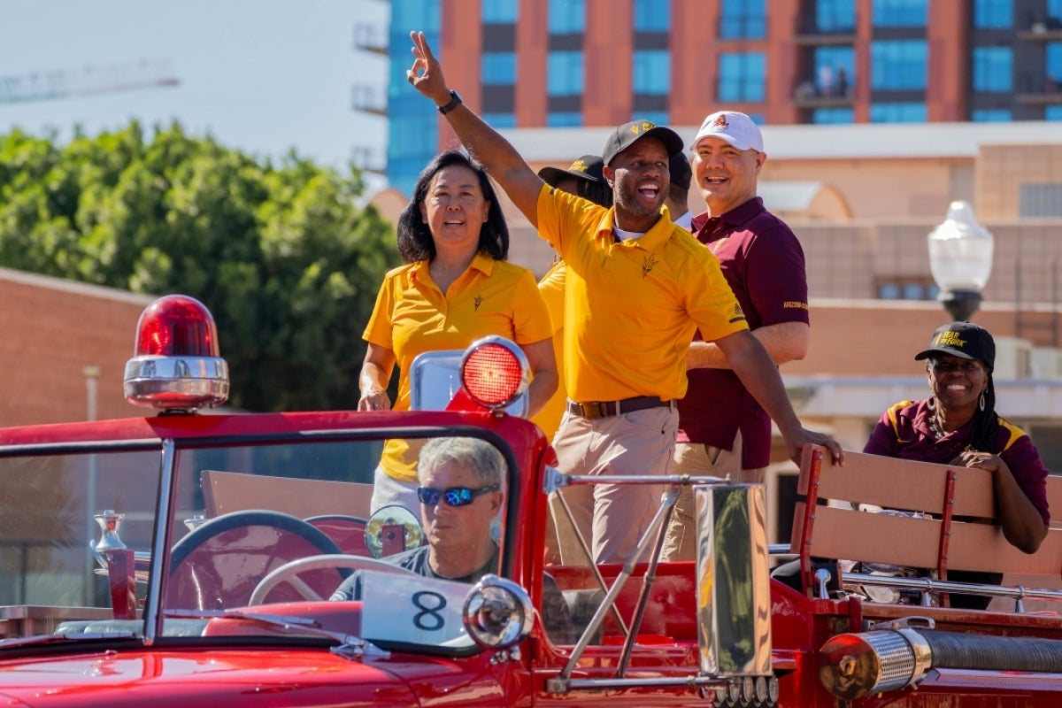 People waving from car in ASU Homecoming Parade