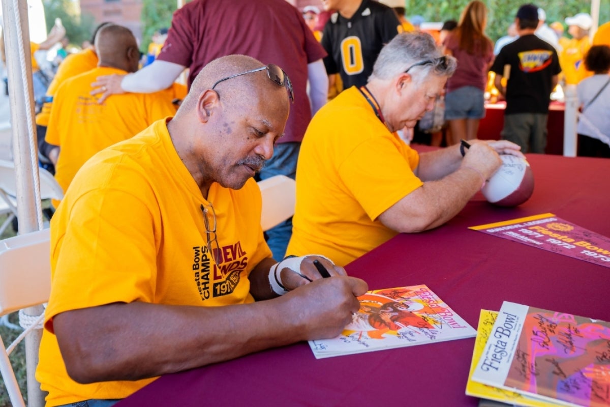 Man signing autograph at Homecoming Block Party