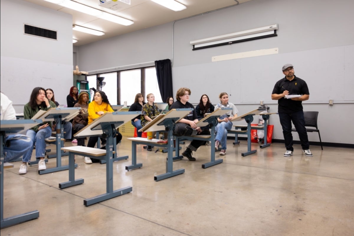 Teacher standing in front of class of art students