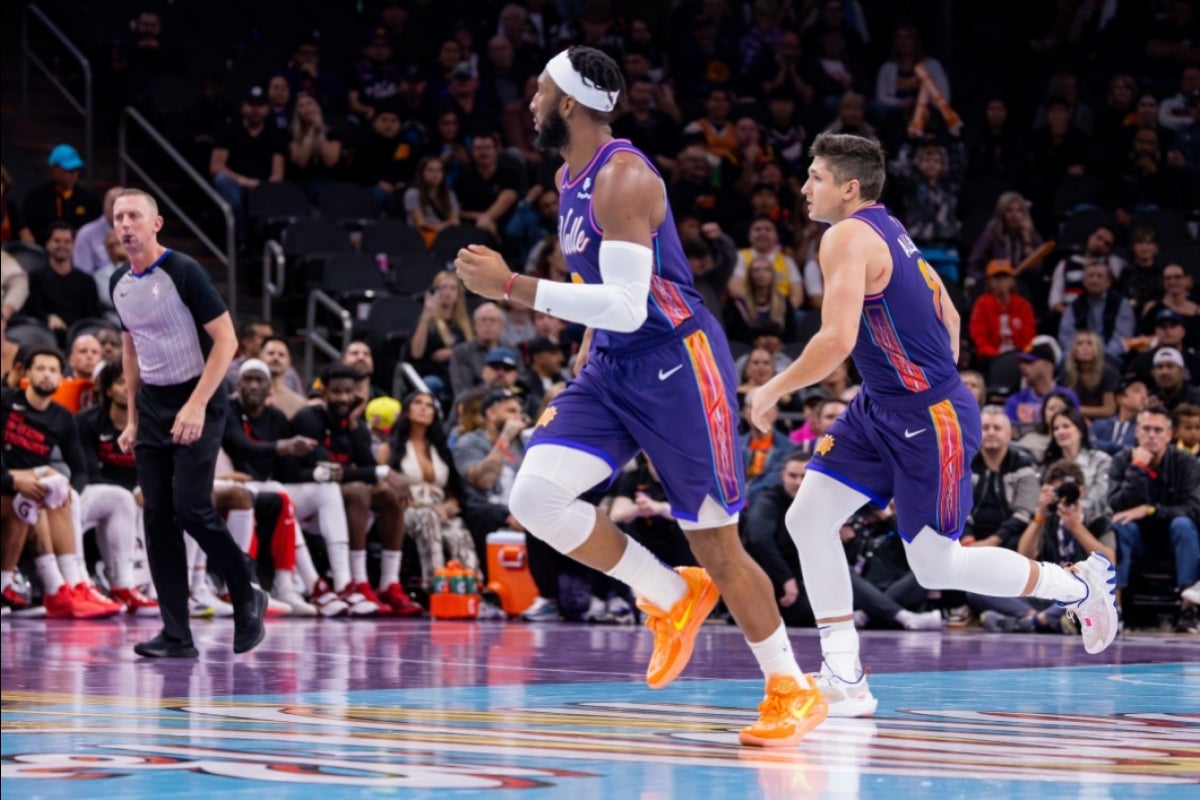 Two basketball players run down the court wearing special edition El Valle jerseys