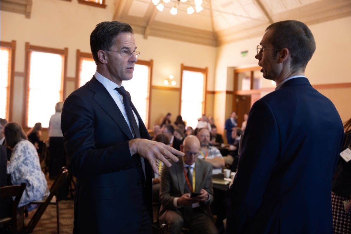 Two men wearing suits talking