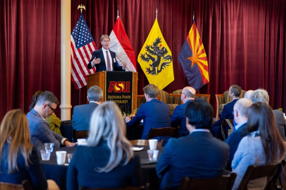 Man speaking at lectern in front of crowd