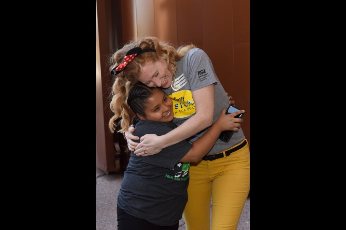 Teacher hugging her student.