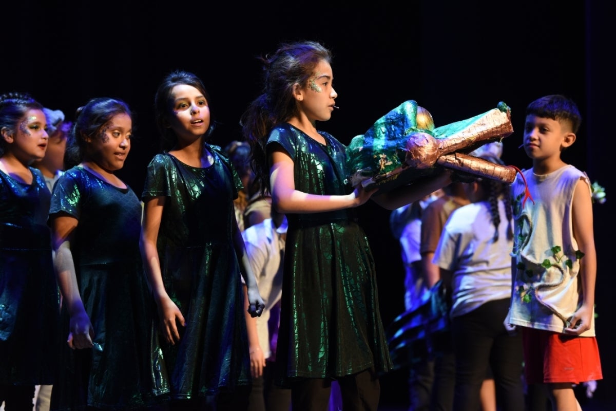 Group of children performing on stage.