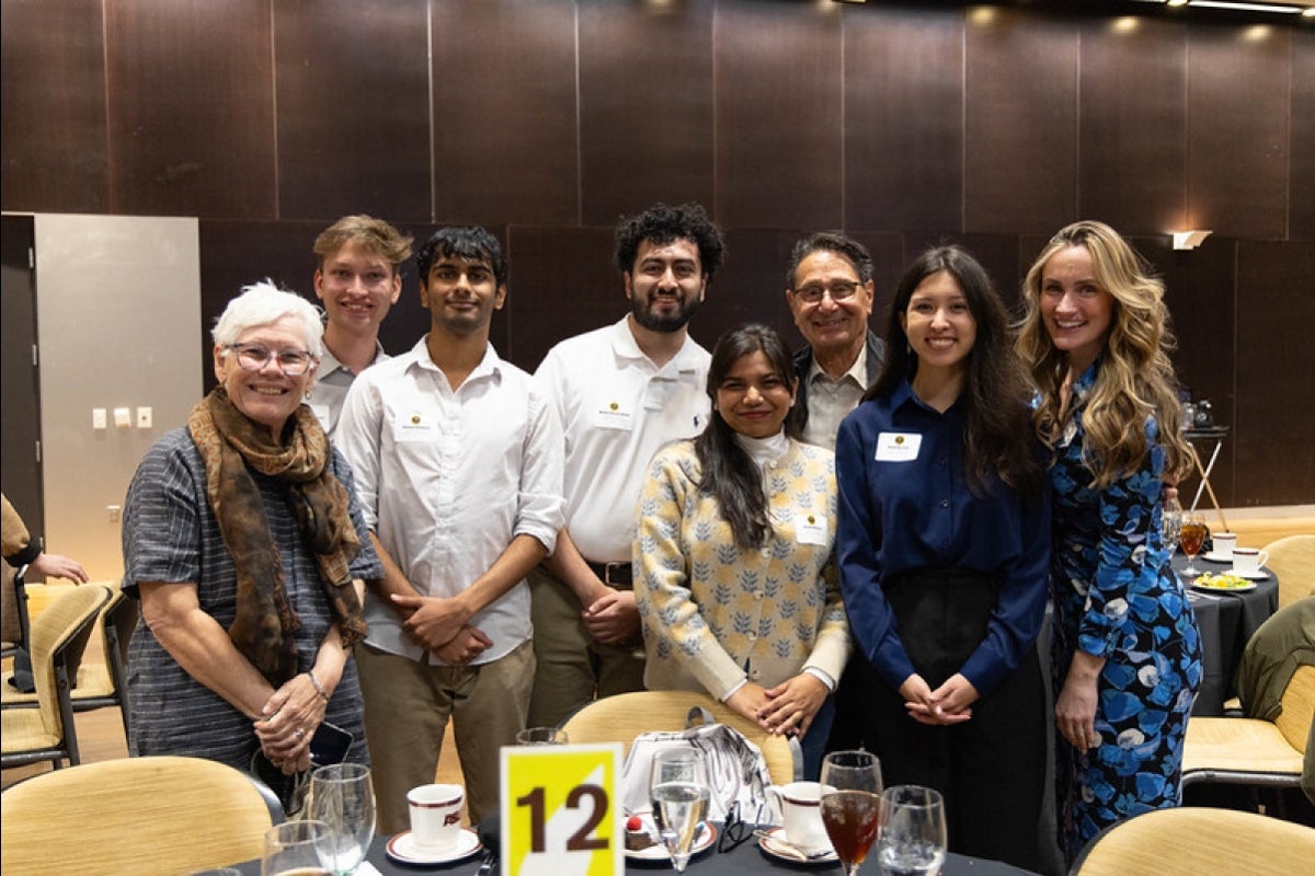 Students and donors pose for a group photo in an event space.