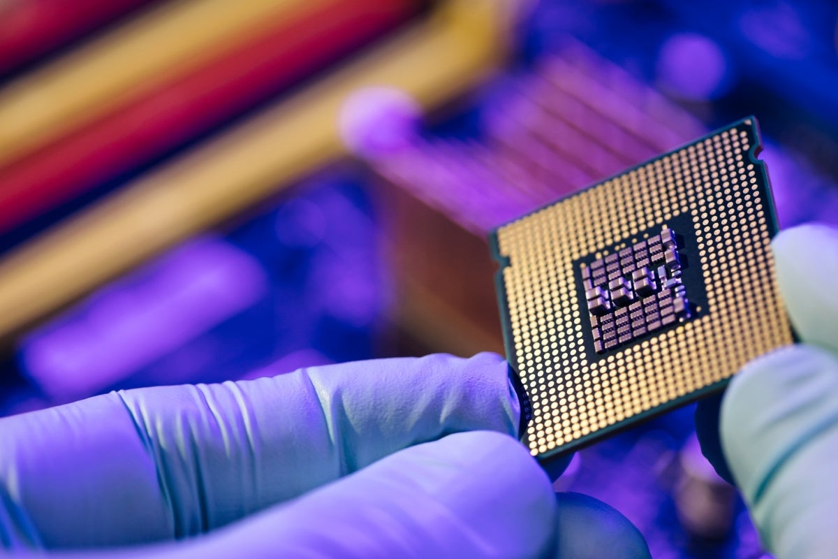 Gloved hand holding computer chip