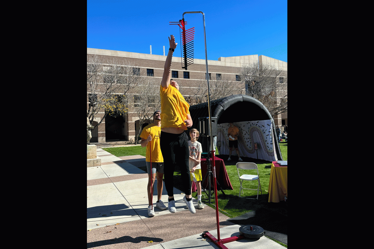 A person leaps up to tap a swinging device