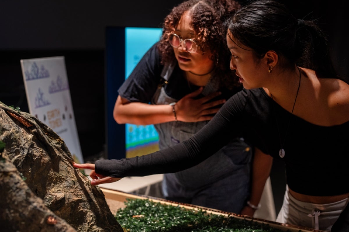 Students touching a sculpture.