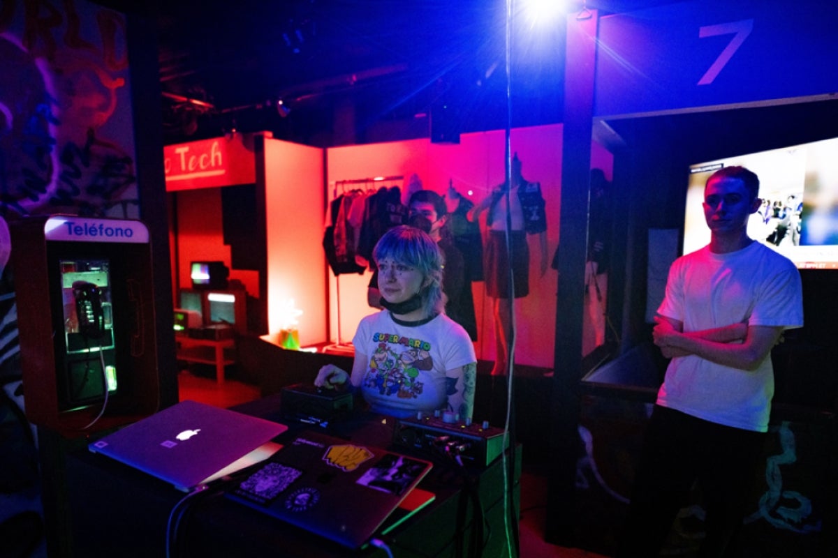 People using computer controllers to change audio-visual elements in an art installation.