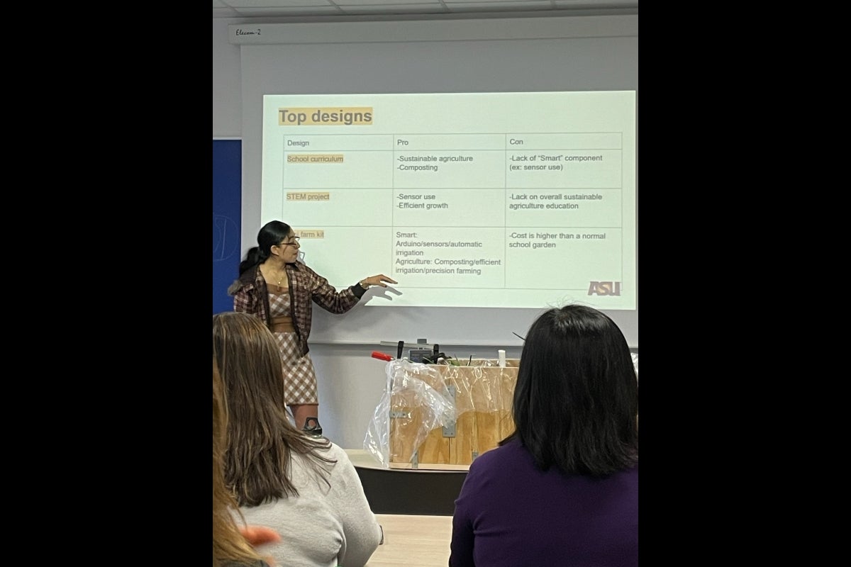 Engineering student presents in front of a projector screen