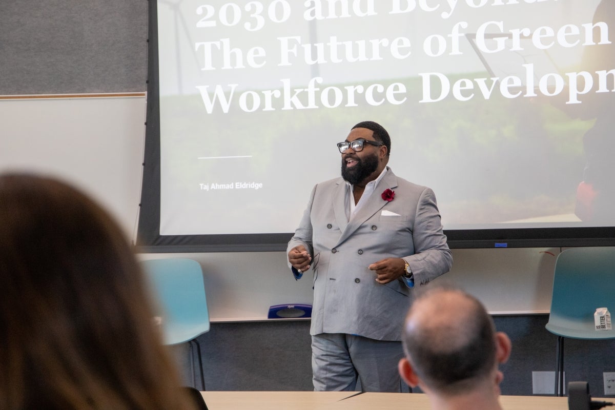 Man speaking at the front of a classroom.