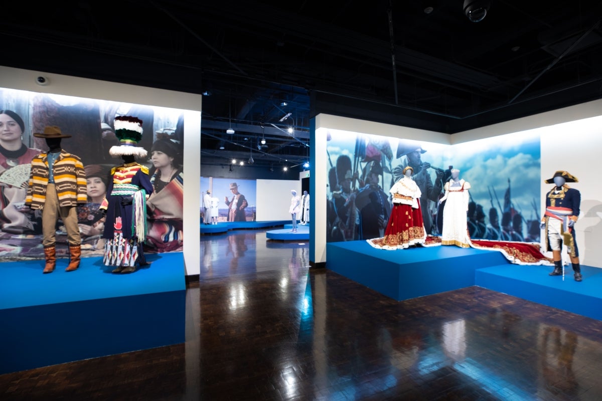 Costumes on display in a museum gallery.