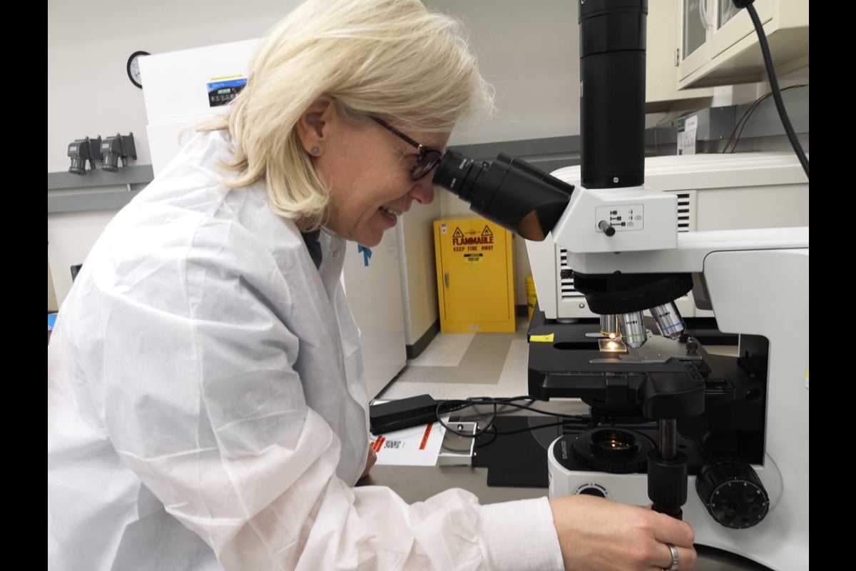 Woman looking into a microscope.