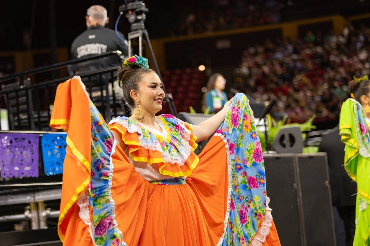 Woman dressed in mariachi outfit dancing