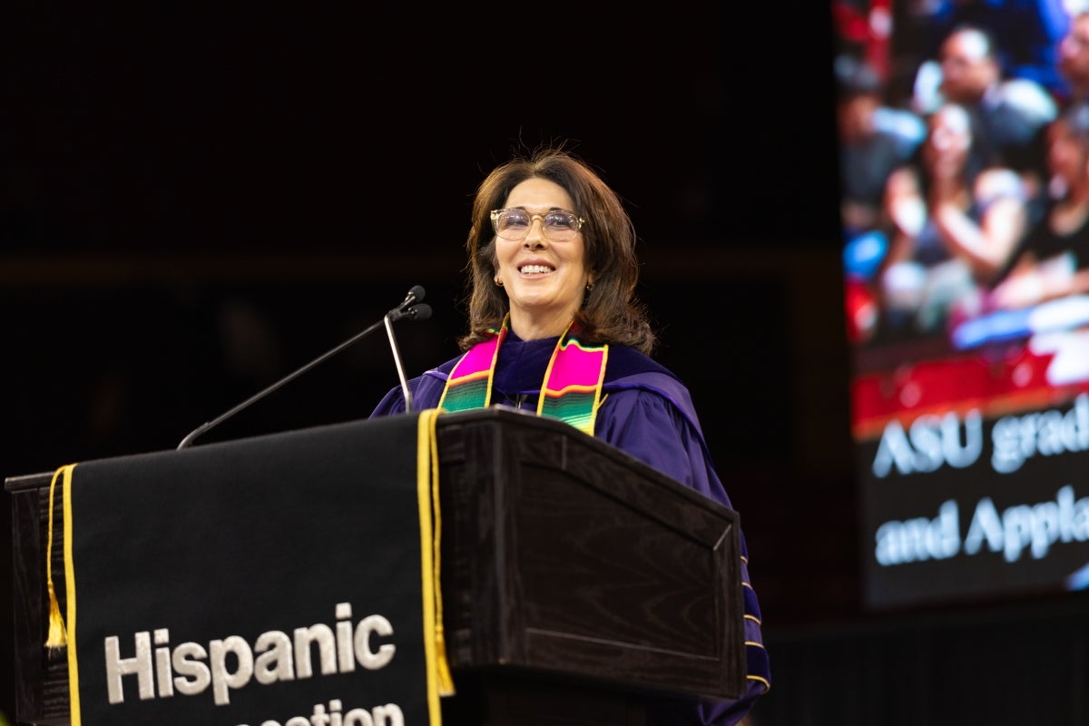 Woman speaking behind lectern at commencement