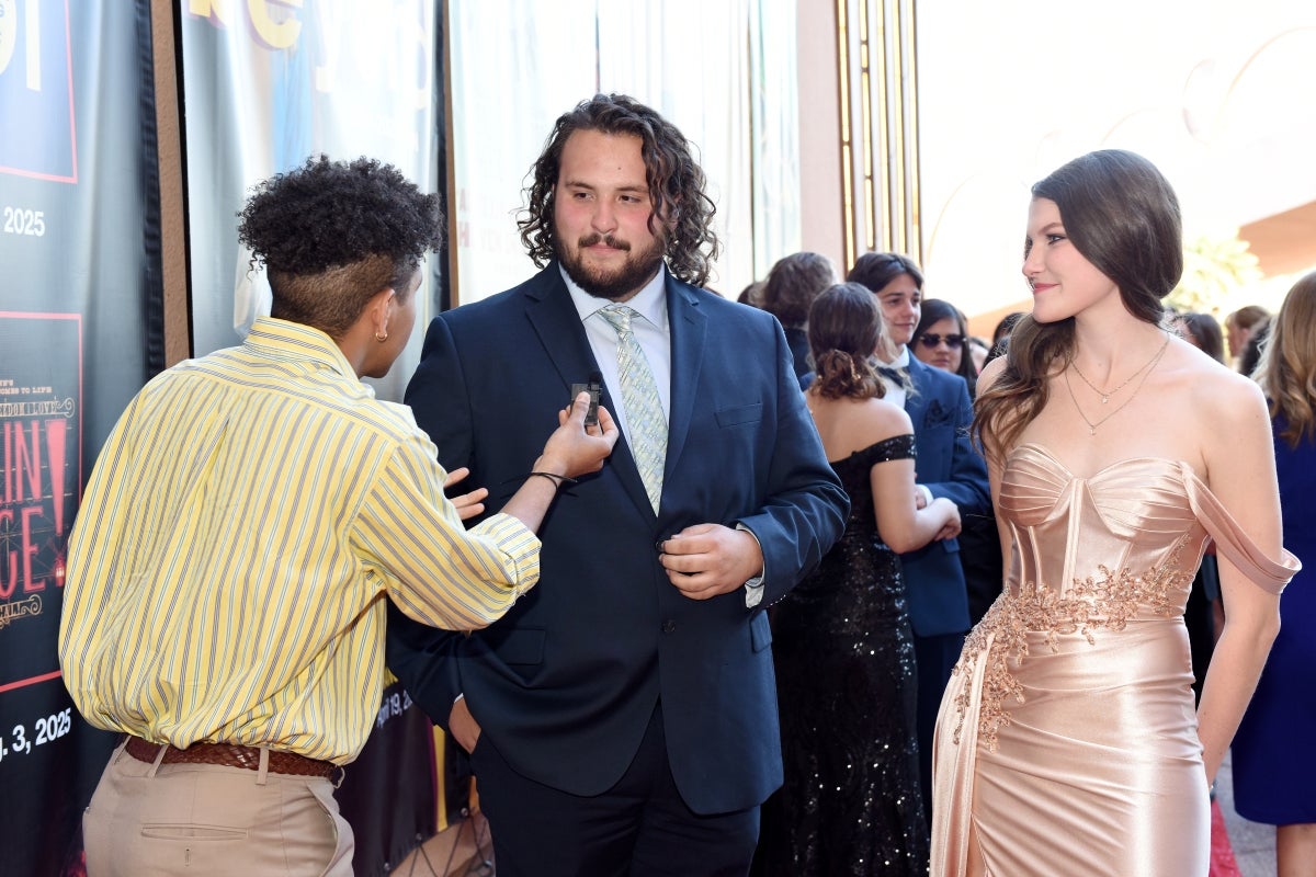 Man being interviewed on a red carpet.