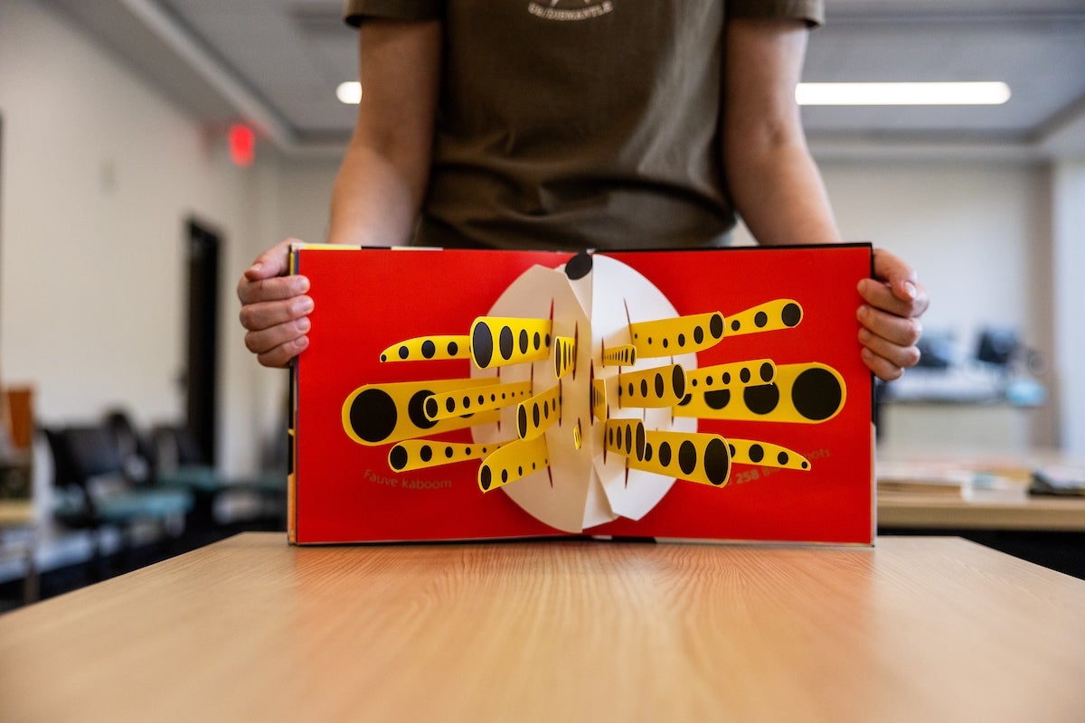 Hands holding a movable book.