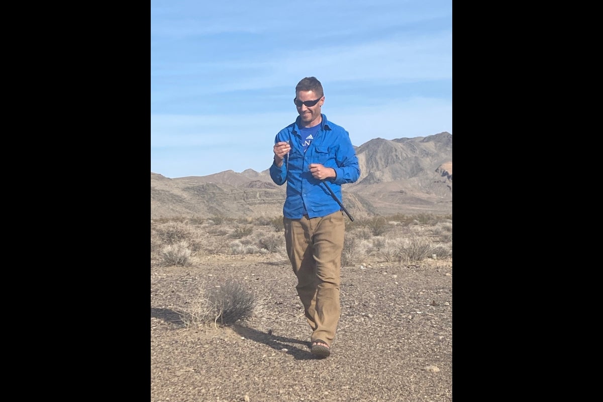 Anthony Barley holds a lizard in the desert