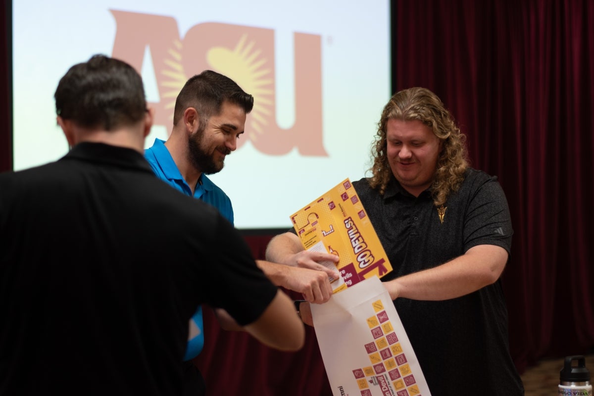 Three people handling envelopes and papers with an 