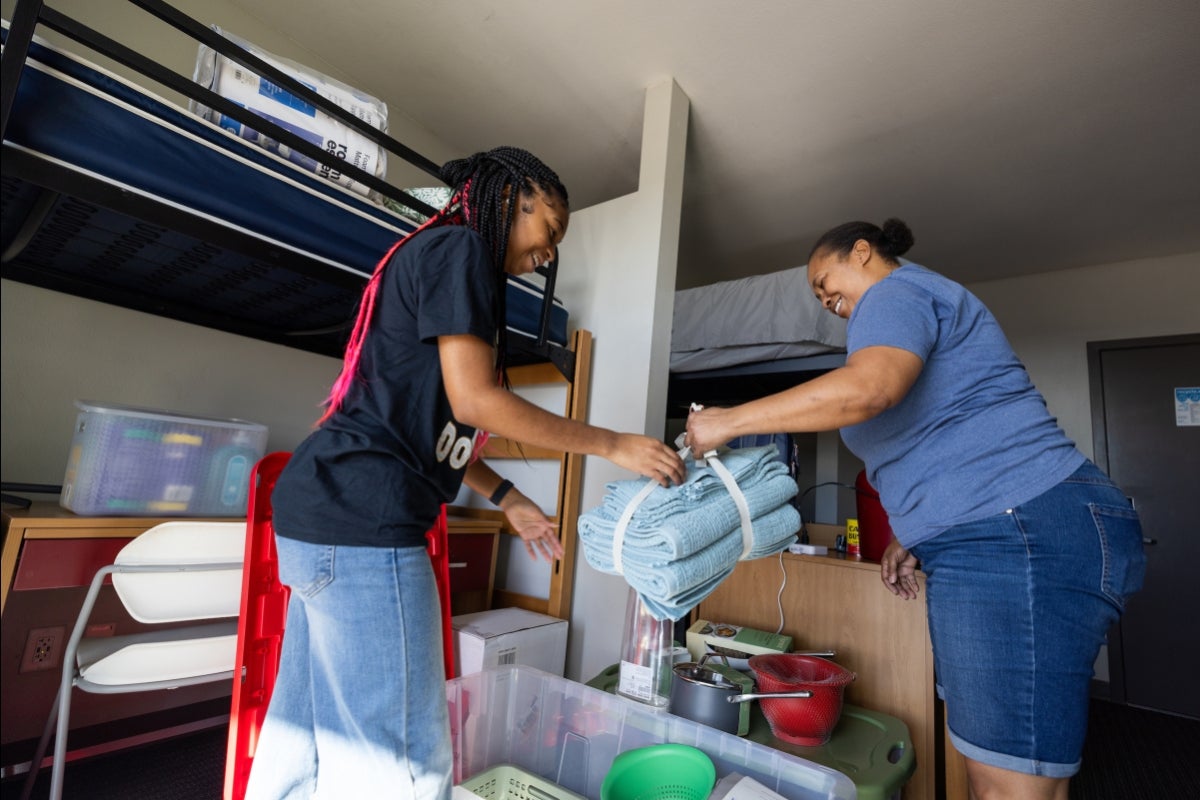 Mother and daughter unpacking items in dorm room