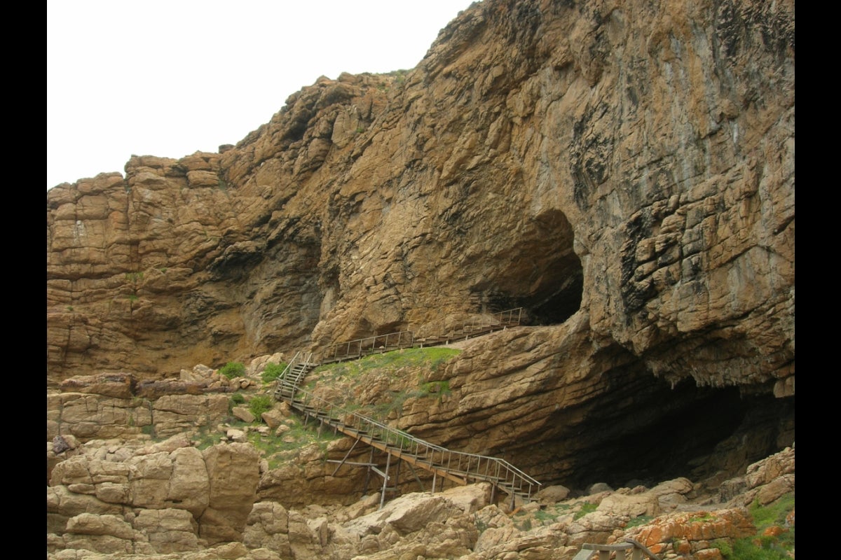 A view from a lower vantage point looking up at the entrance to a cave