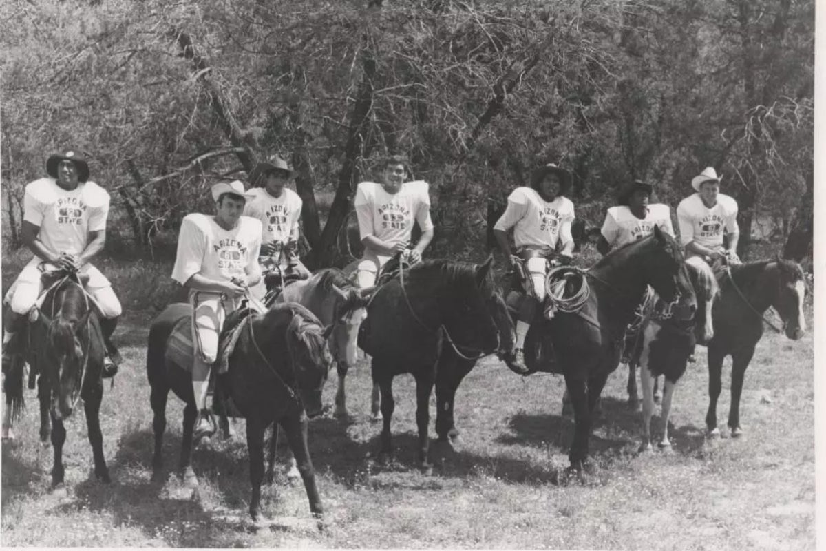 Black and white photo of ASU football players on horseback