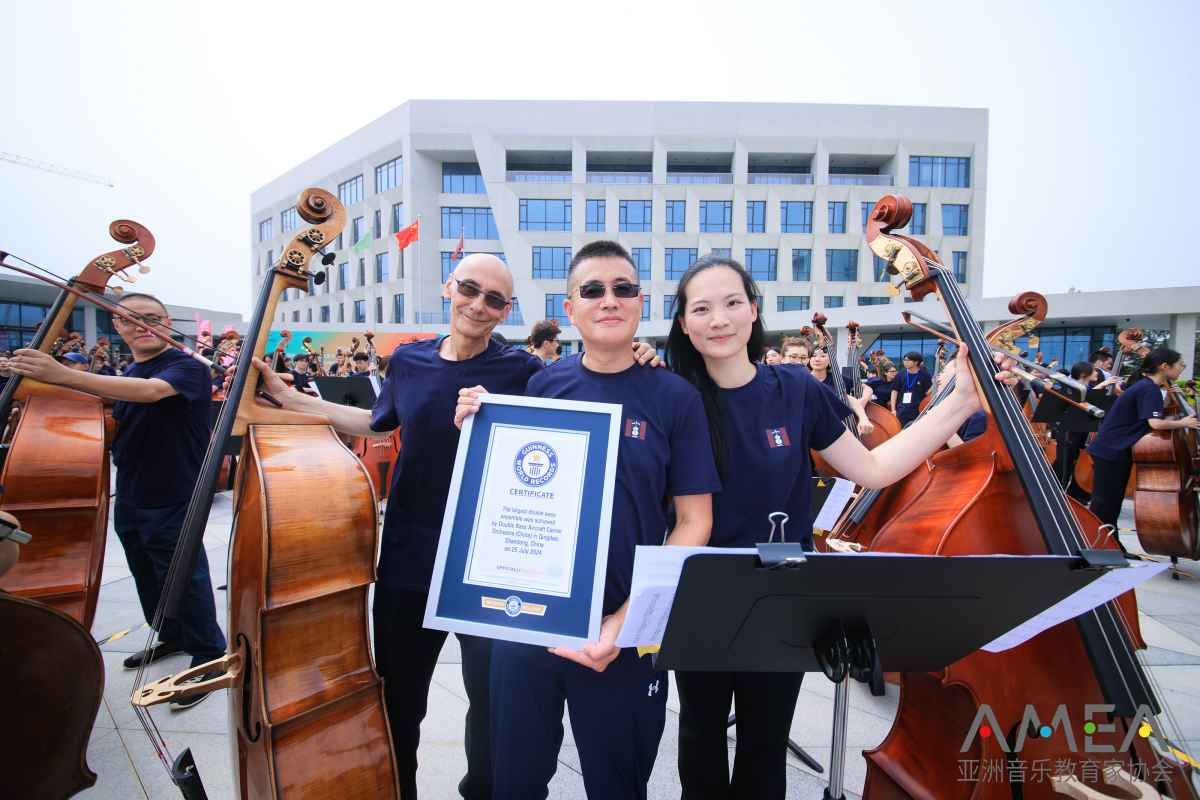 Group of people posing with instruments and a certificate