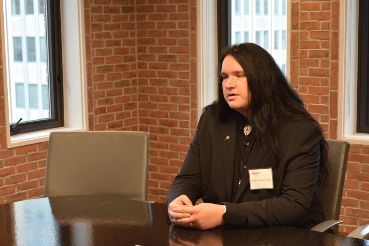 Colton Fredericks-Frazier, a man with long hair wearing a dress shirt and bolo tie