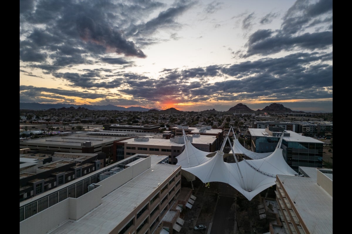 An aerial drone shot of ASU SkySong with the sun setting in the background