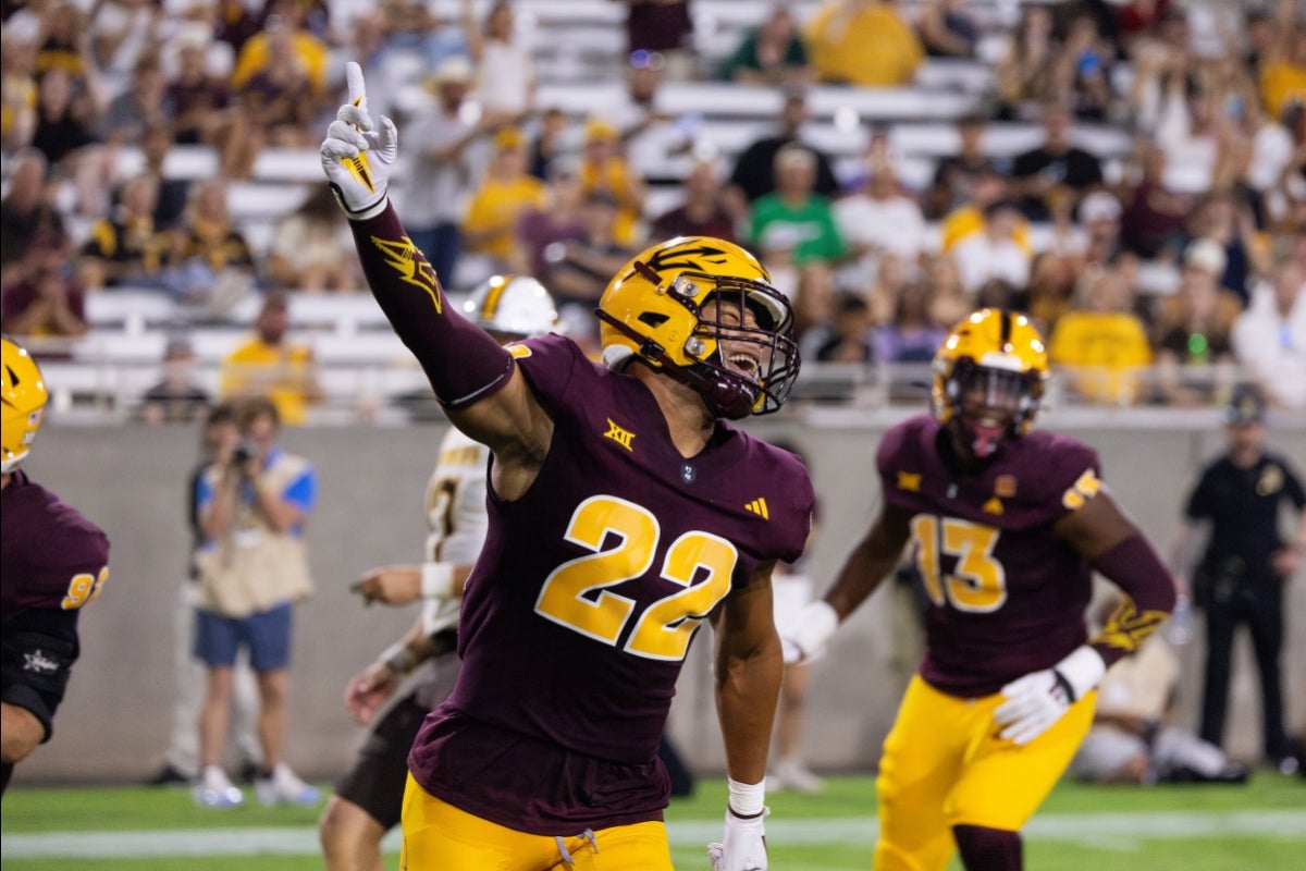 ASU football player with arm raised in celebration after making a touchdown