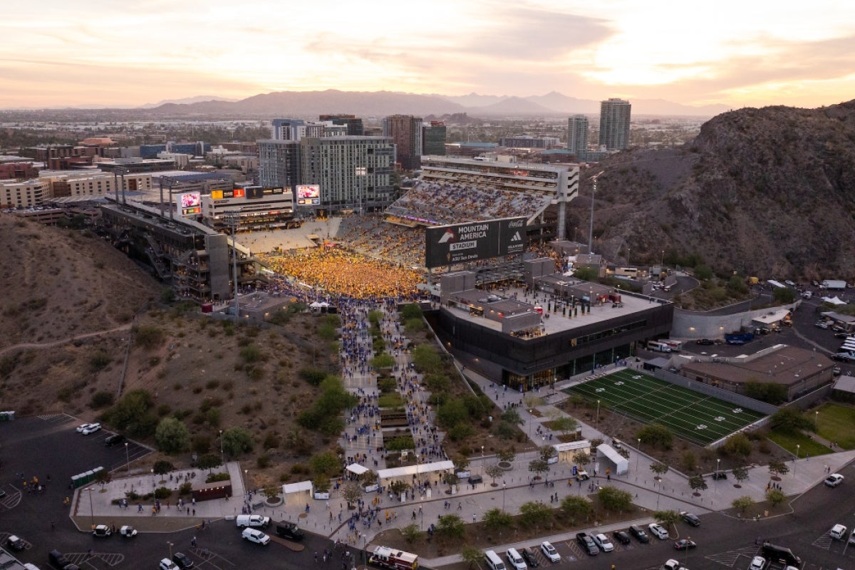 A drone aerial shot of the ASU stadium with the field mobbed by people in gold