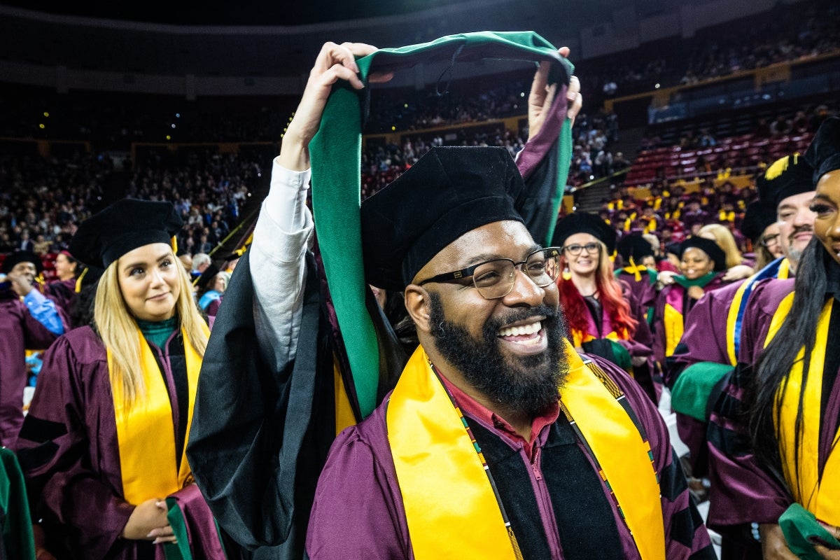 A graduate student is hooded at commencement