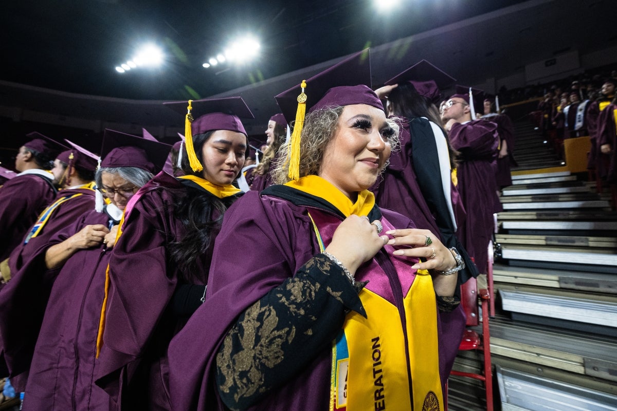 A graduate student is hooded at commencement