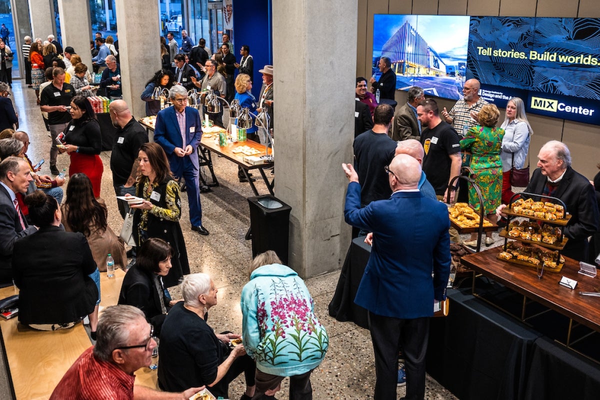 Aerial view of people gathered in a lobby, talking and eating.