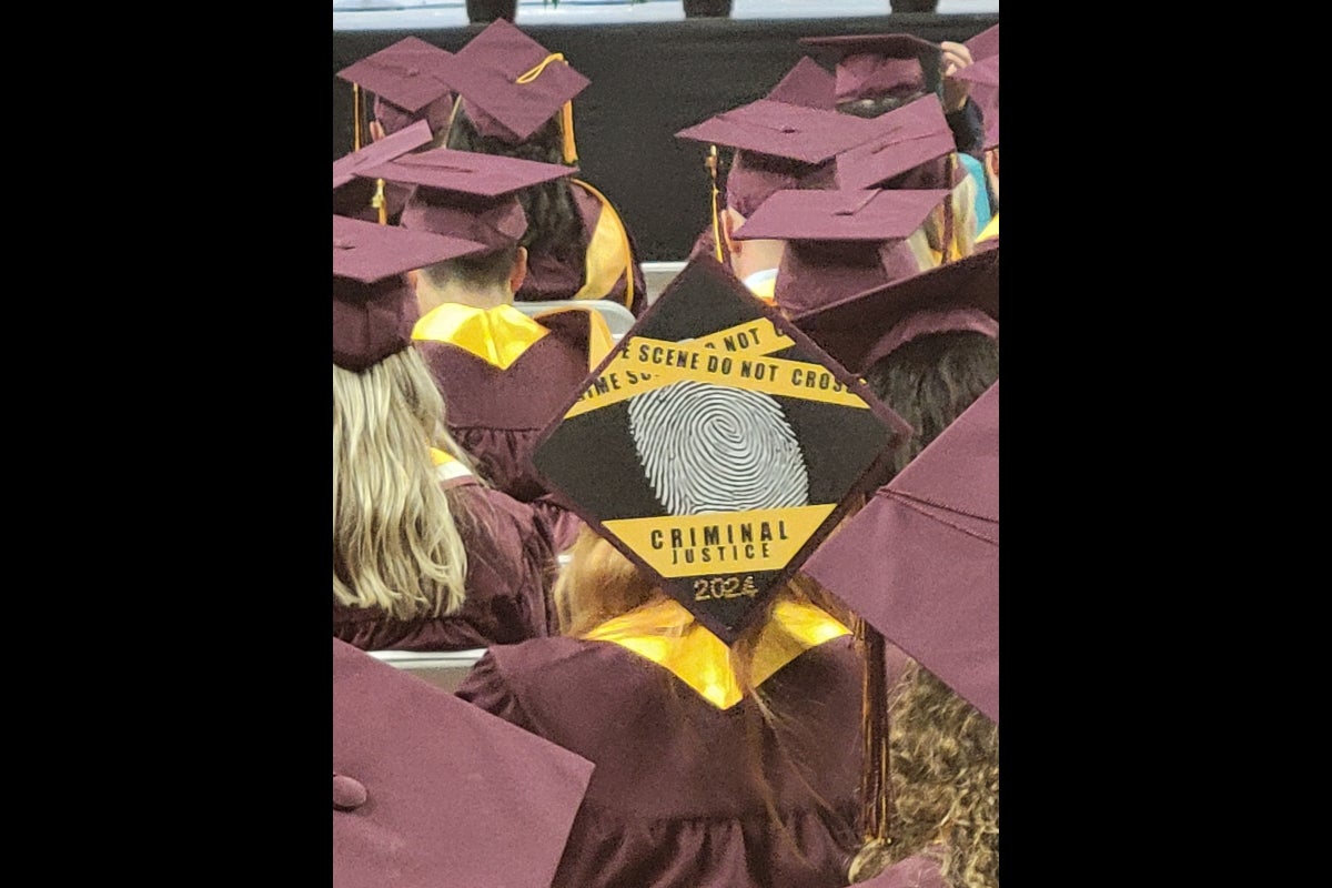 Graduation cap decorated with crime scene tape.