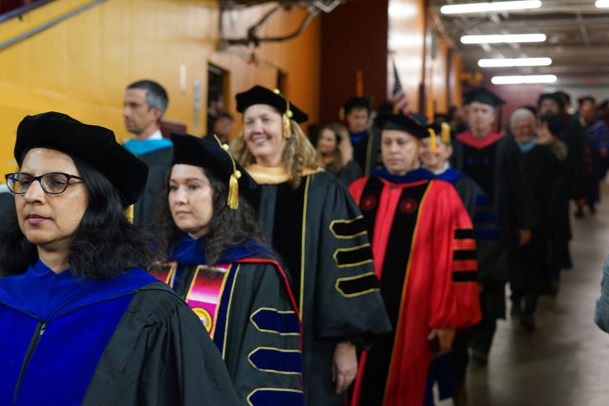 Faculty lined up wearing graduation regalia.