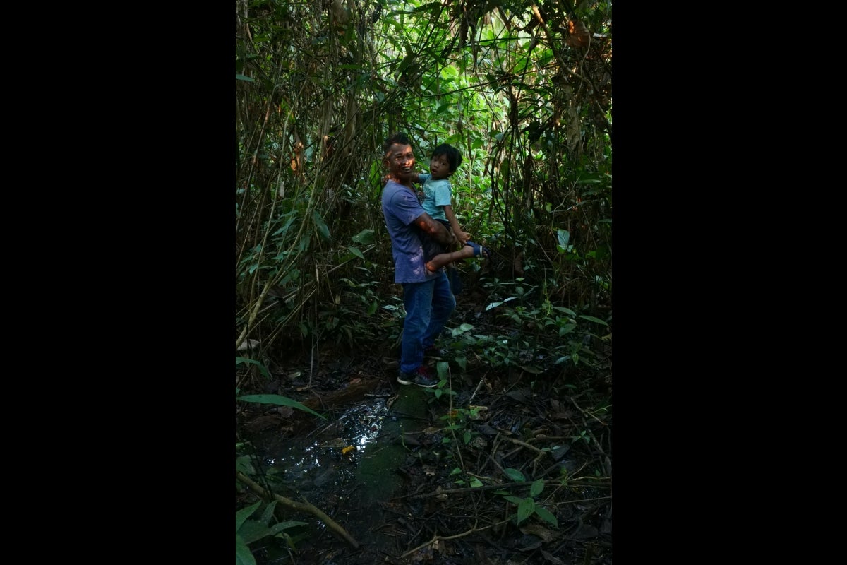 Man and small child in a jungle environment.