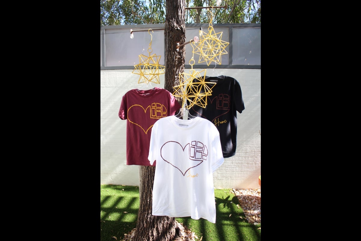 T-shirts with heart graphics on them hanging in a tree.