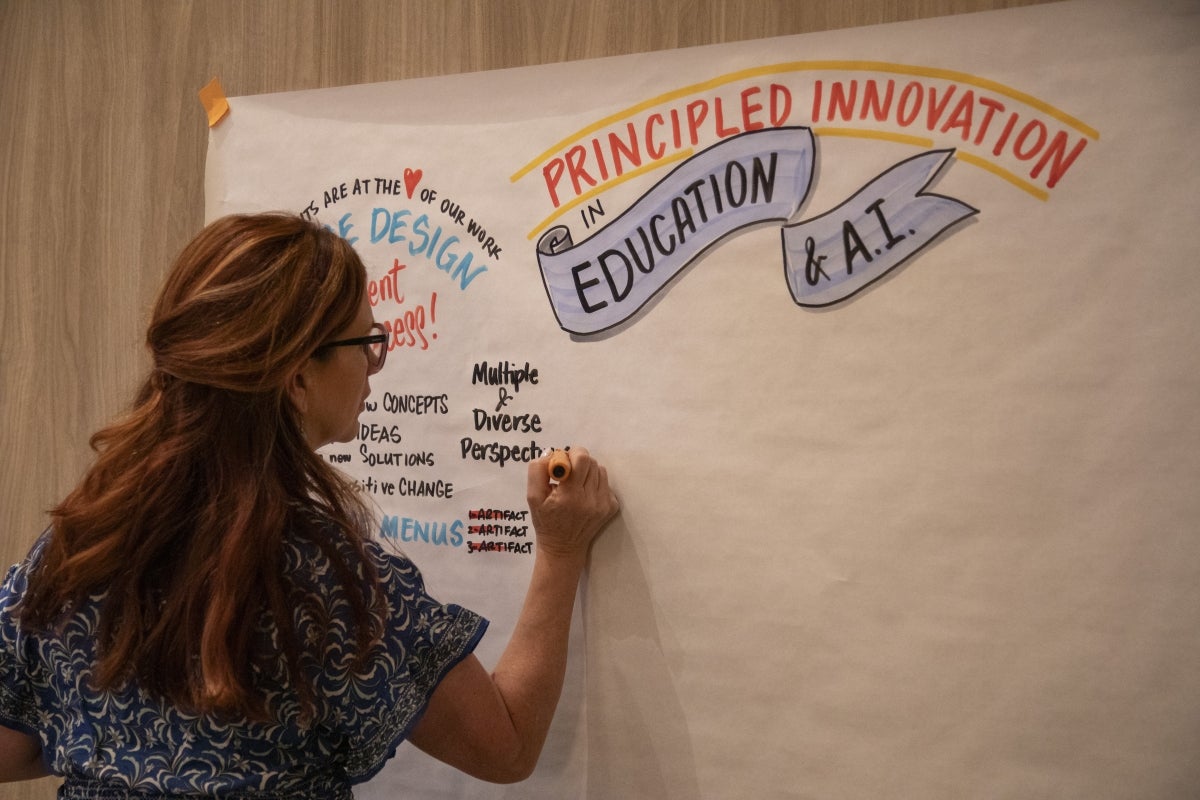 Woman writing on a large sheet of paper.