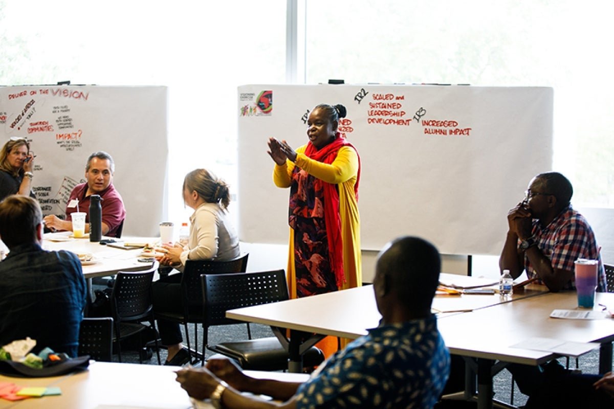 A woman speaks to a room full of people