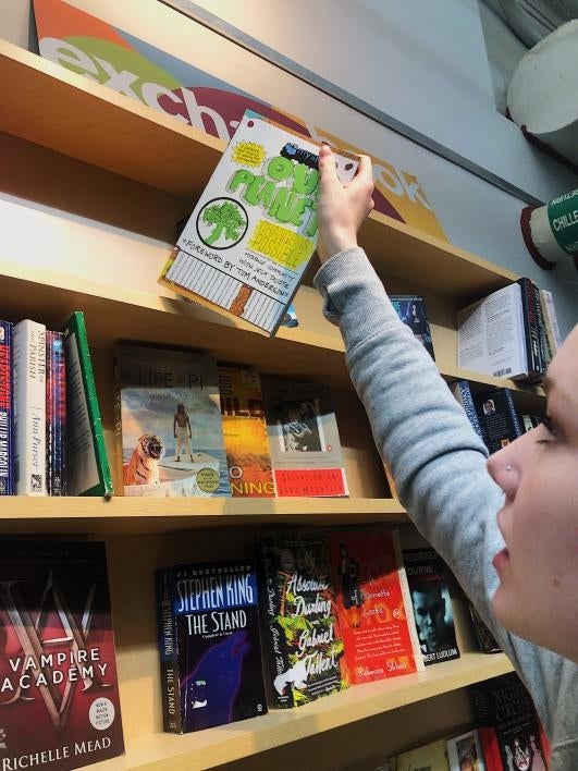 student takes a book off a shelf