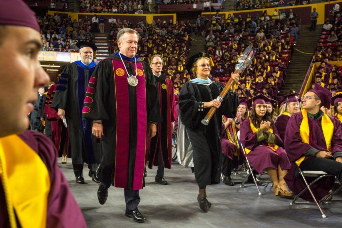 two people leading graduation procession