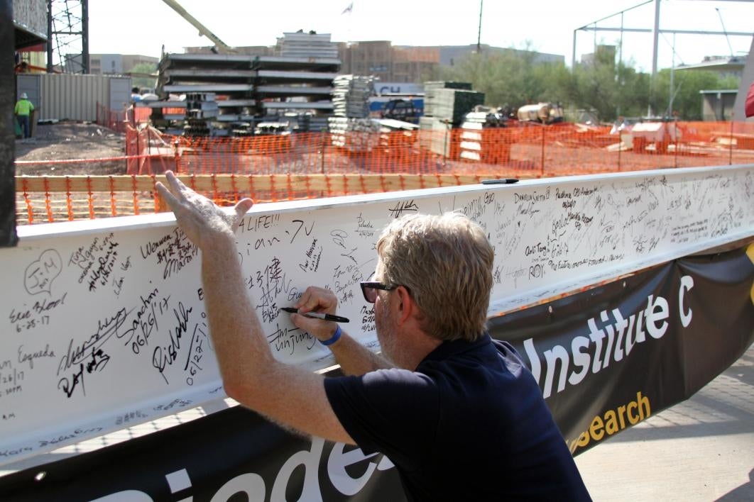 People sign the final beam for Biodesign C