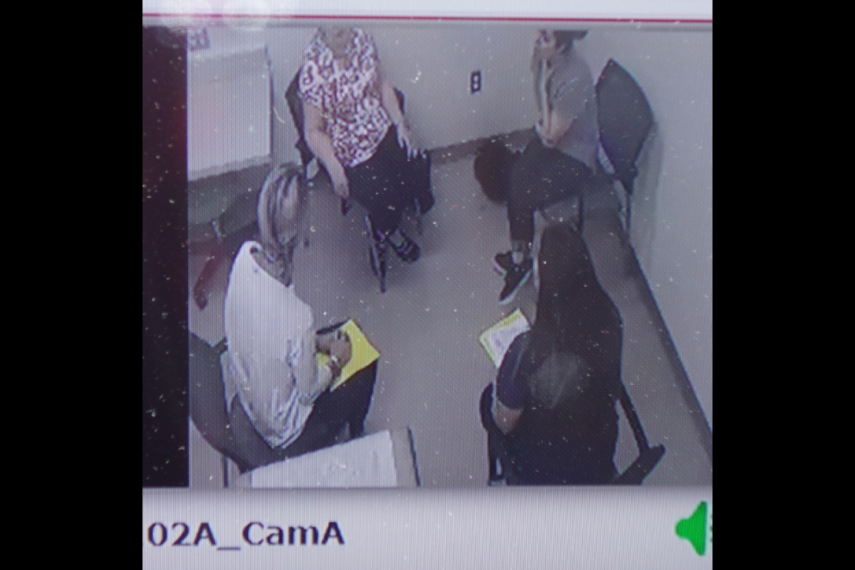 Two doctor of nursing practice students sit across from two women portraying a patient and family member during a simulated health care scenario.