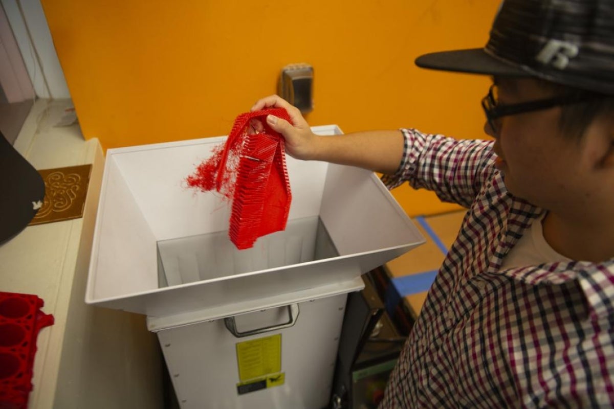 A student holds a piece of plastic over the reclaimer tool.