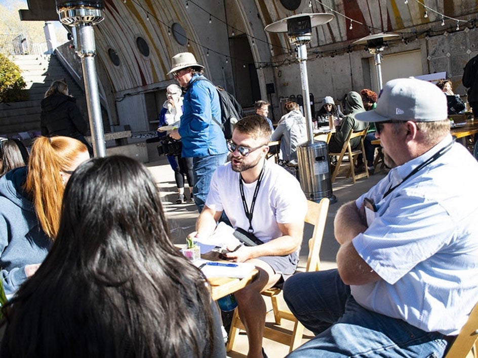 People sit around an outdoor table talking during OpenCitizen group work