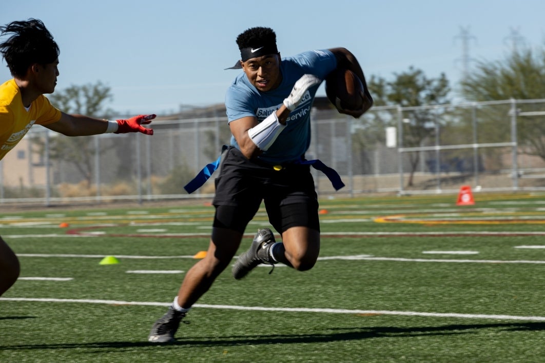 Student runs across the football field during the game.