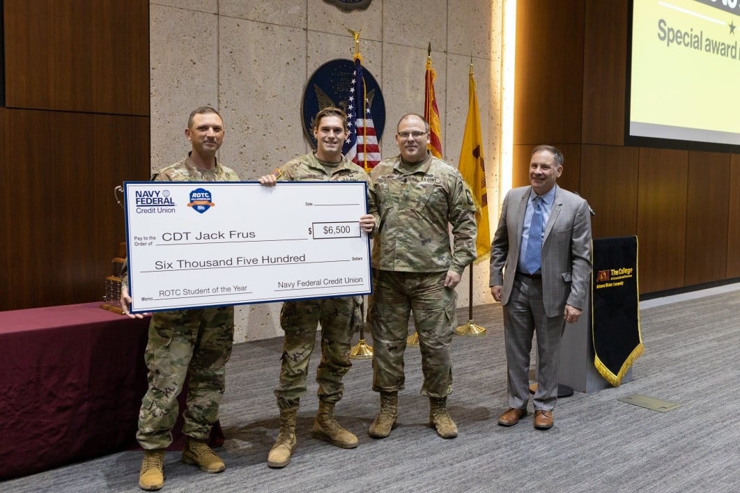 Cadet Battalion Commander Jack Frus stands to receive his scholarship.