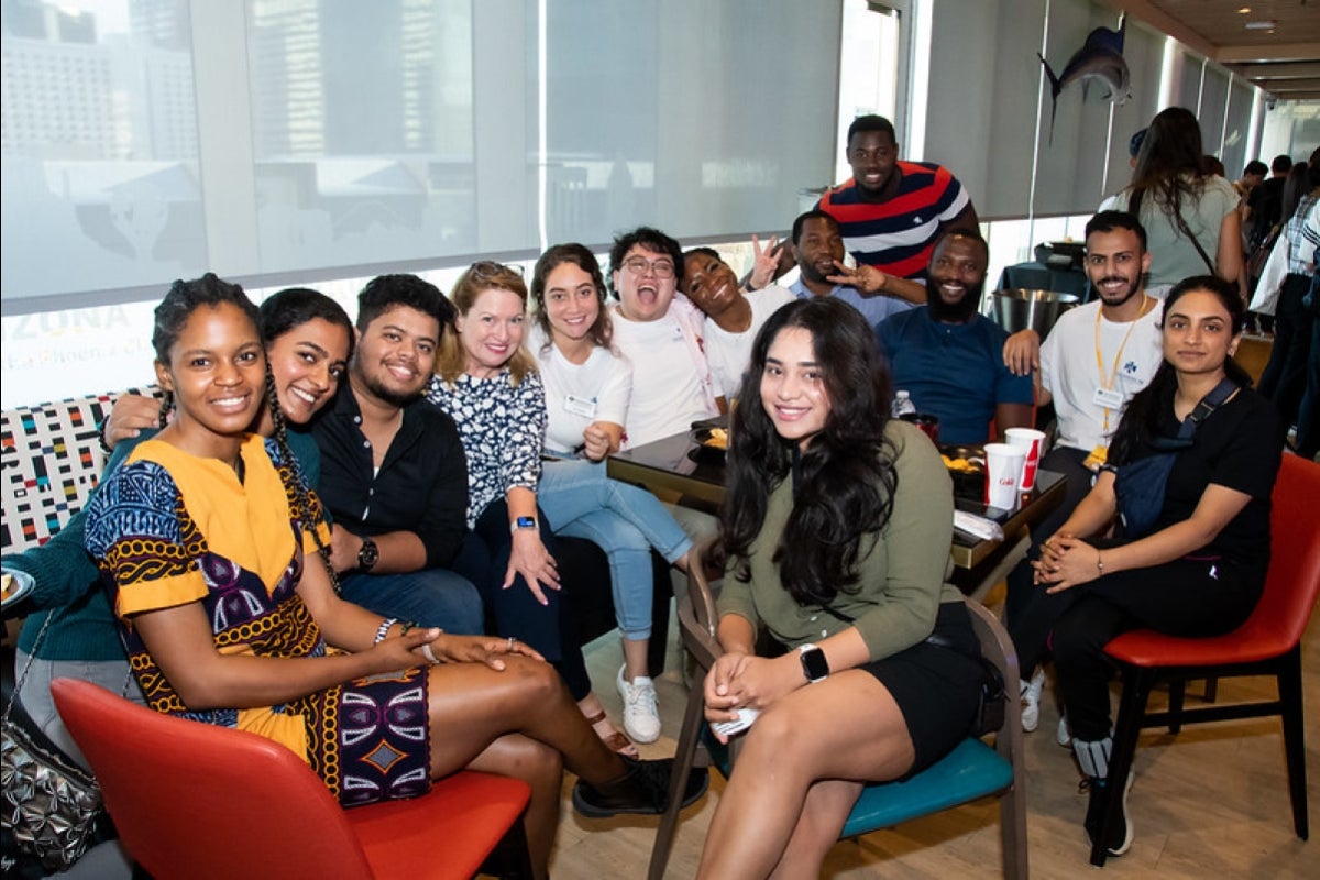 A group of students sit together smiling.