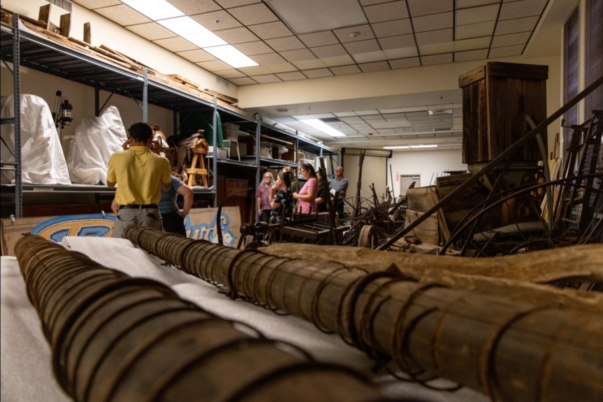 People in a storage room at a museum looking at signs on shelves.